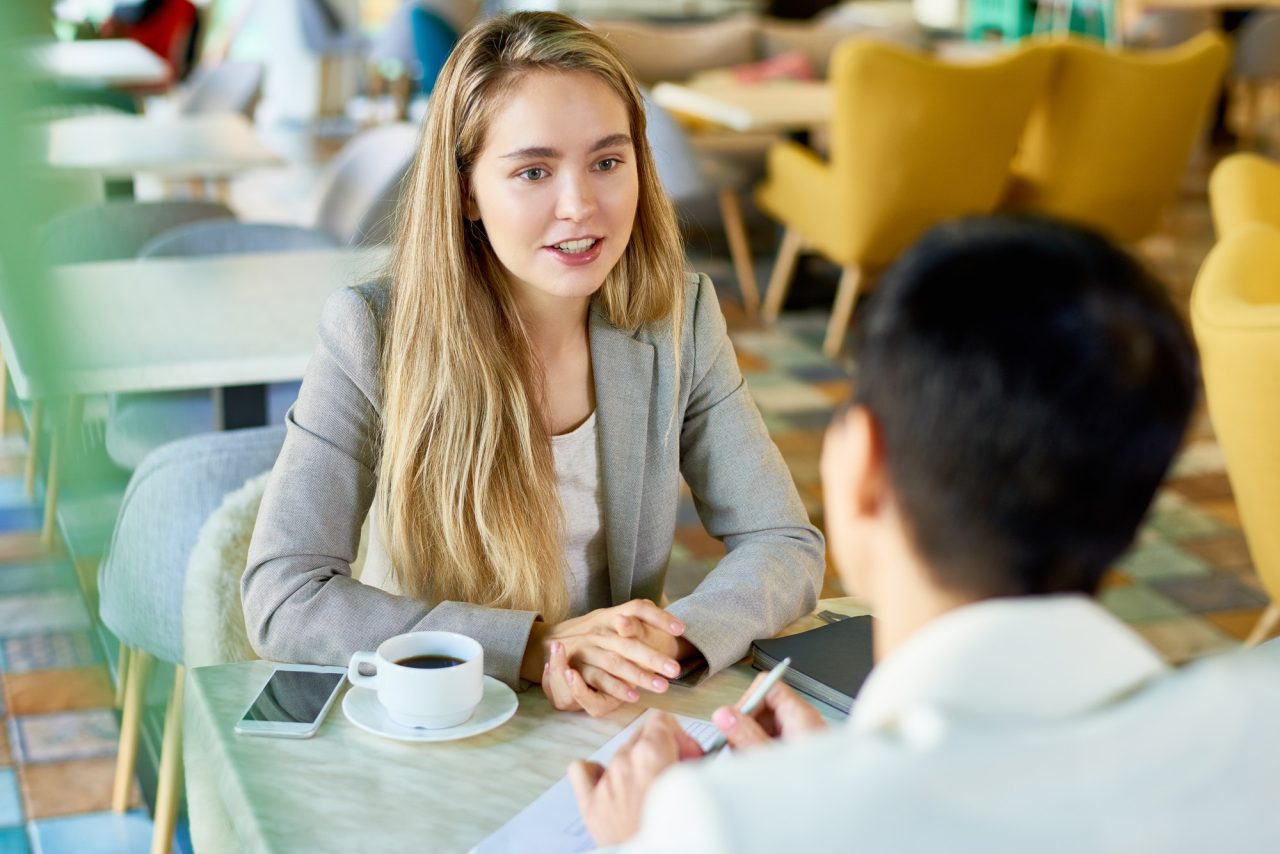 two business women meeting at cafe table